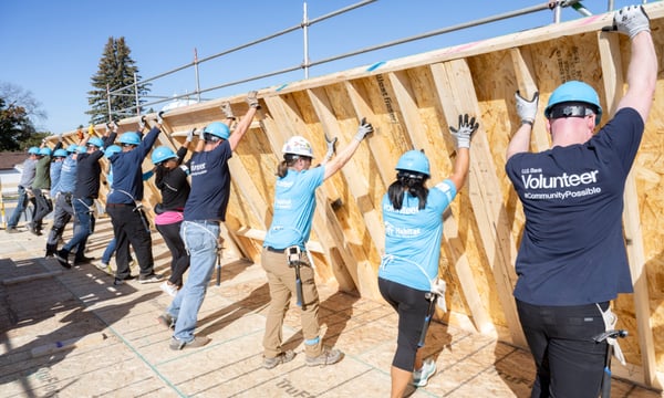 Habitat volunteers raising a wall.