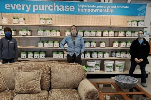 Photo of ReStore employees standing in front of paint gallons