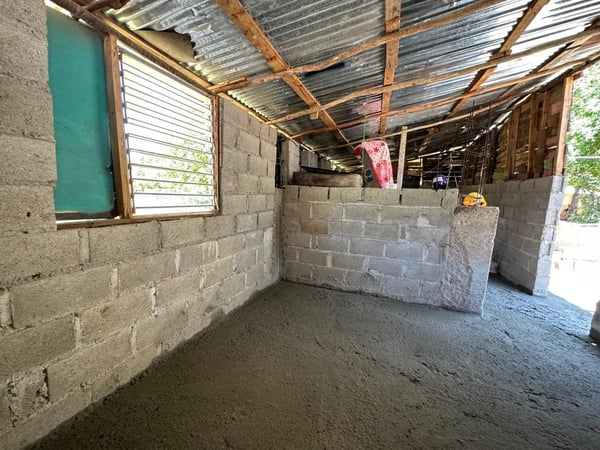 Interior of a small home with a freshly laid concrete floor.