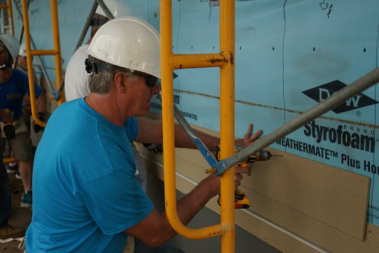 Chris Coleman, President & CEO of Twin Cities Habitat, installing some siding.