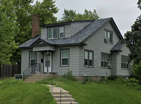 Exterior of a grey two-story house and yard