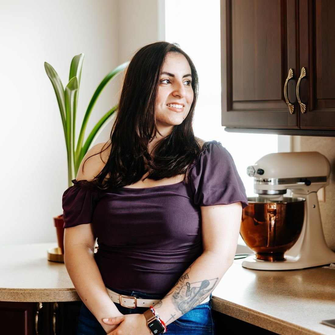 Linda smiling in her kitchen and looking out the window.