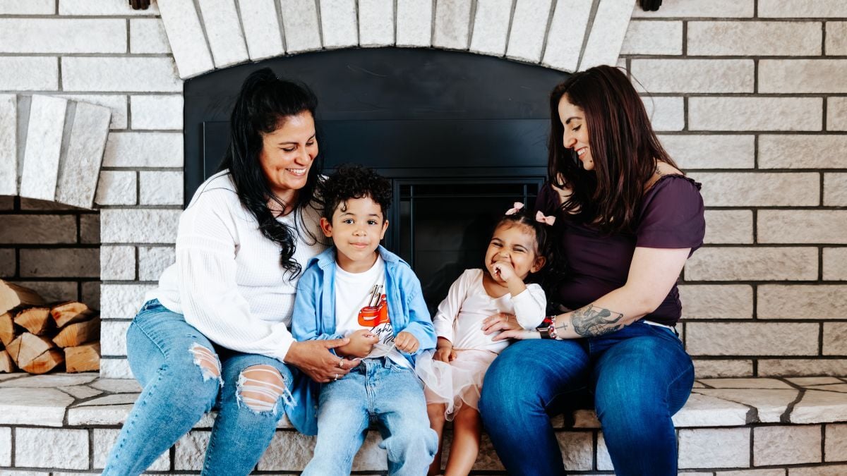 Linda, Linda's kids, and Linda's mom sitting in front of the fireplace.