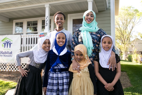 Habitat homeowner and her five children in front of their house