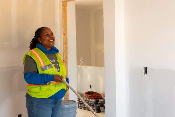 Smiling volunteer wearing a yellow safety vest.