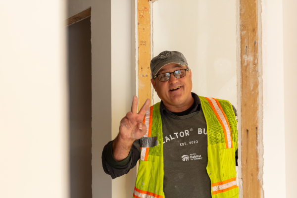 Smiling volunteer giving a peace sign.