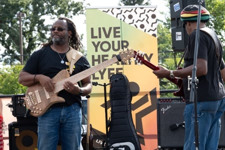 Two guitarists on stage at an outdoor event.