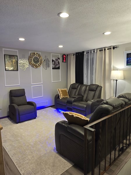 Redecorated living room with black leather furniture set.