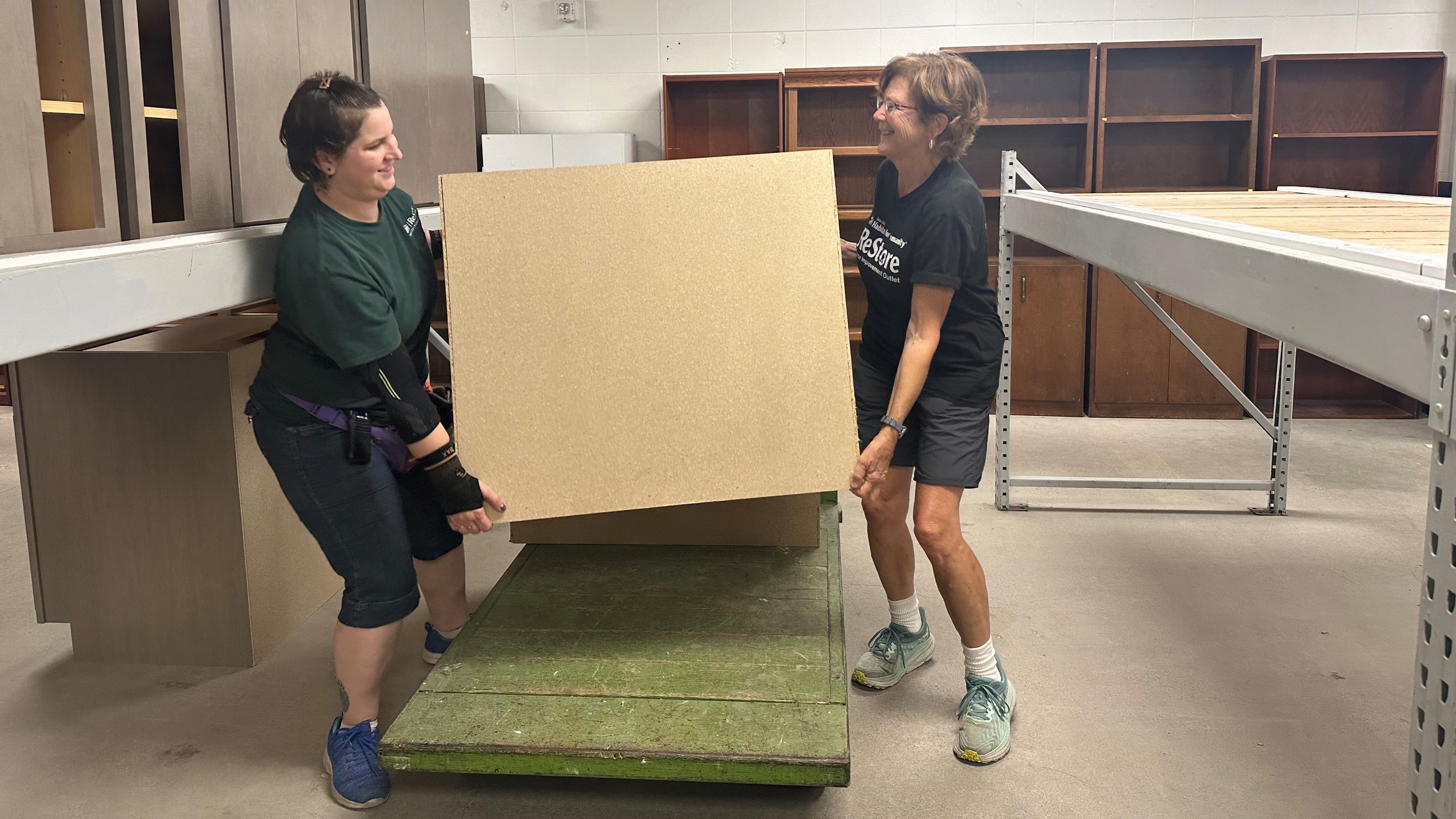 Donna and staff member move cabinets at ReStore.
