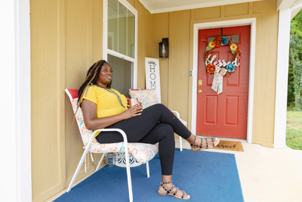 Habitat homeowner relaxing in a chair on her front porch.