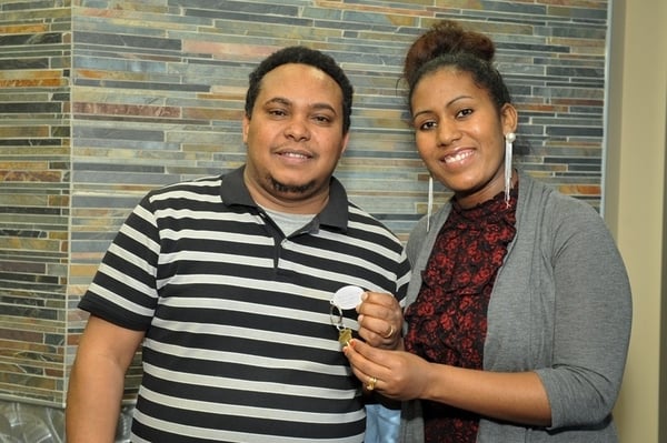 Two Habitat homeowners holding the keys to their new home.