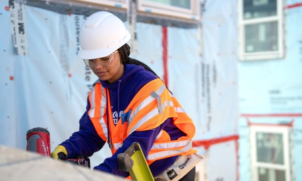 Volunteer in hard hat and vest.