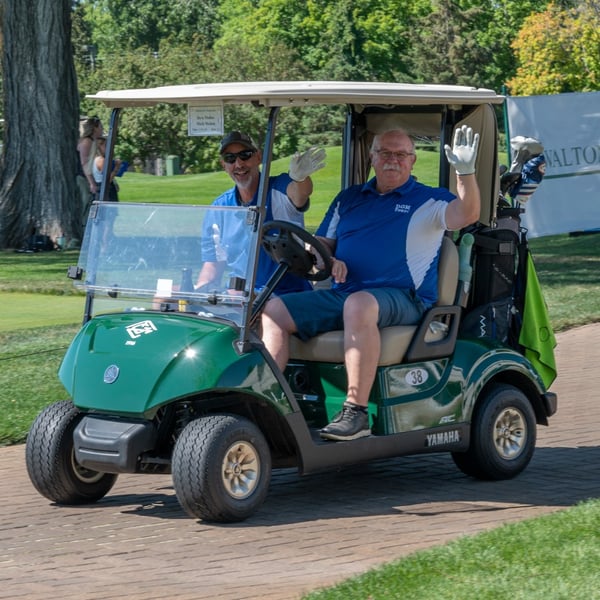 Golfers in a golf cart.