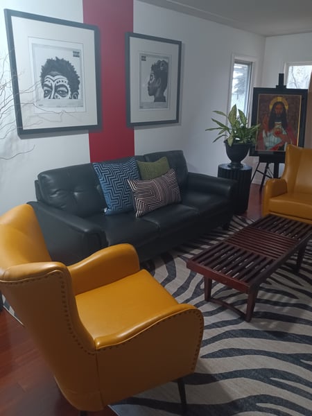 Living room with black couch and yellow armchairs.