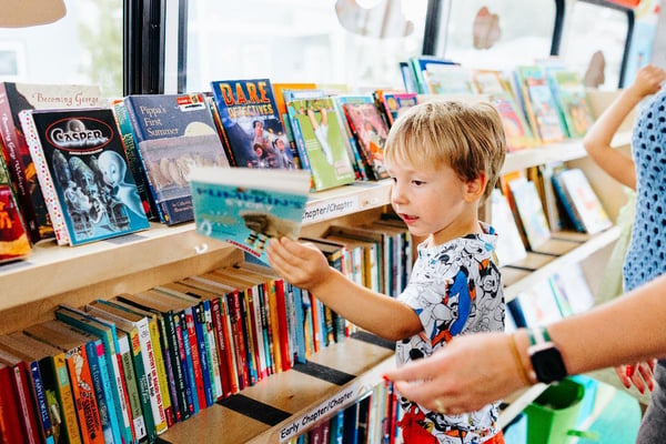 Child picking out a book.