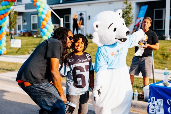 Parent and child meeting the mascot.