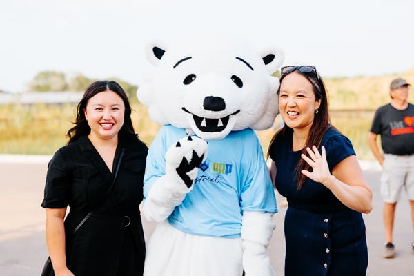Two women posing with the mascot.