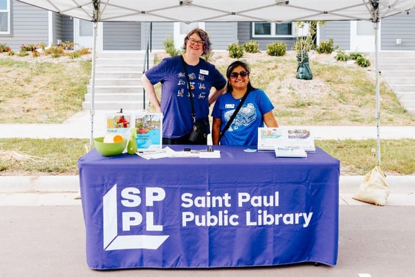 Two women at a Saint Paul Public Library vendor table.