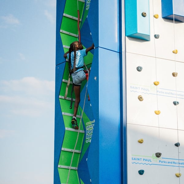 Child scaling a rock-climbing wall.