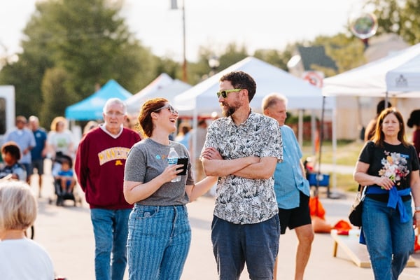 Two people laughing in the crowd.