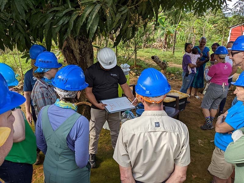 The team getting instructions from site supervisor Roberto for staging the concrete mixing.