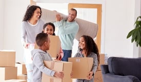 Family carrying moving boxes