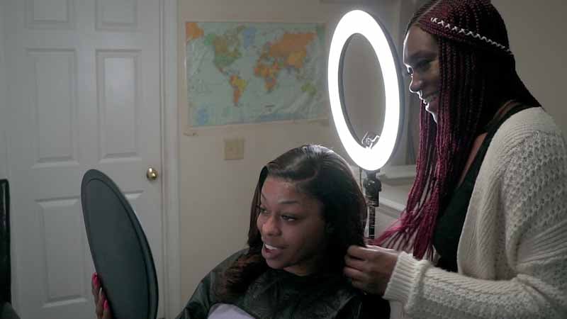 Vera doing a client's hair in her home.