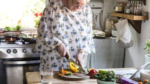 A woman chopping vegetables.