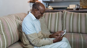 A man on his couch with a tablet computer.
