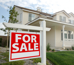 Red For Sale sign in front of a house