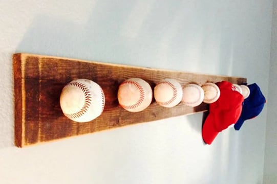 A coat rack made using baseballs as the hooks.