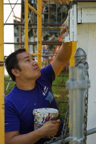 A U.S. Bank volunteer focuses on painting Cassandra's home.
