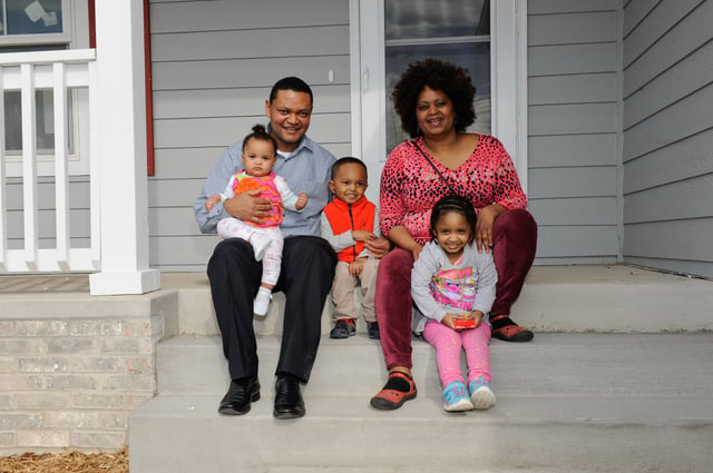 Melkamu and Fasika and family in front of their new home.