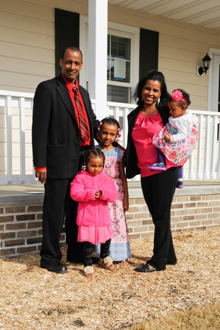 Samson and Margitu and family in front of their new home.