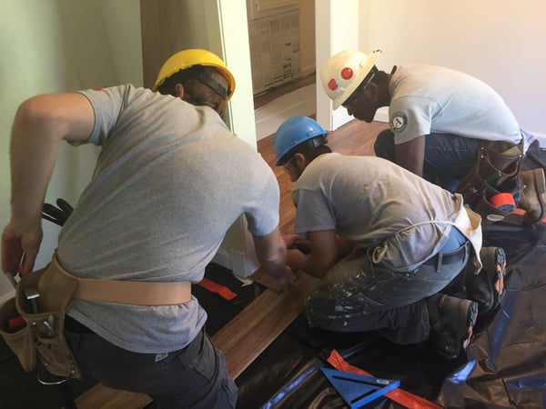 AmeriCorps members laying floors