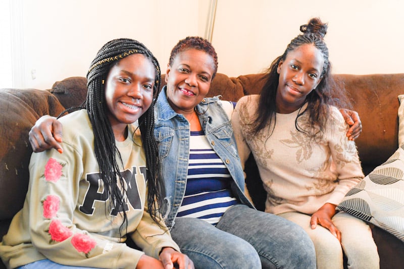 Melo with daughters on their couch