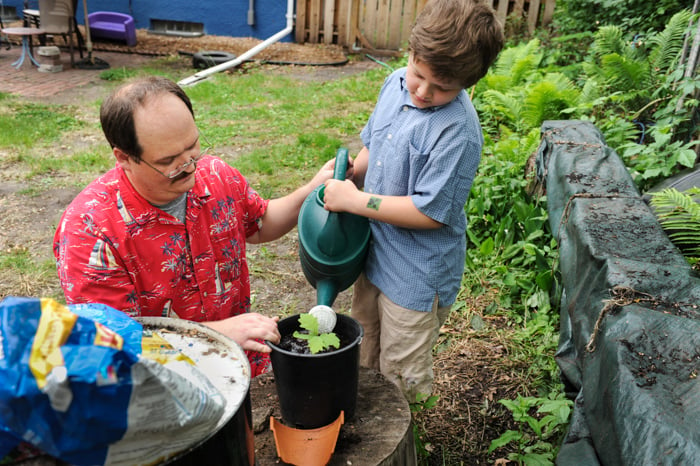 Erik and his dad watering a plant