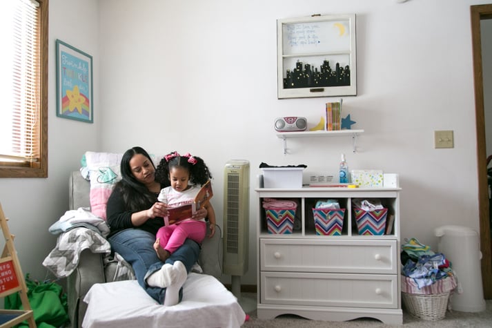 Kera reading with her daughter in their home.