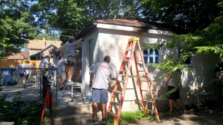 Volunteers painting the exterior of the home.