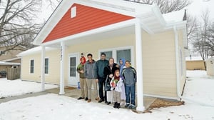 A family in front of their Habitat home in the winter.