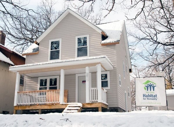 Exterior shot of a Habitat home in winter with a Habitat sign out front.