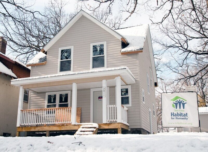 A picture of the front of a new Habitat Home lightly dusted with snow