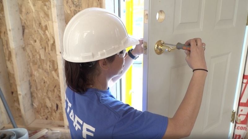 A person installing a doorknob.
