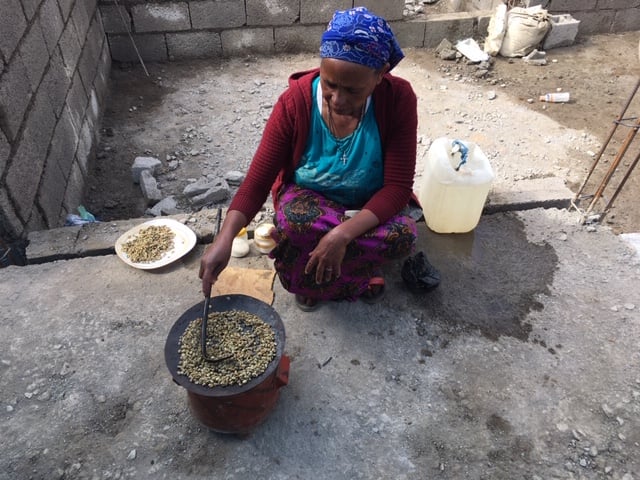 A woman roasting coffee beans.