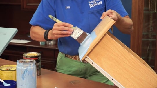Jan painting a drawer.
