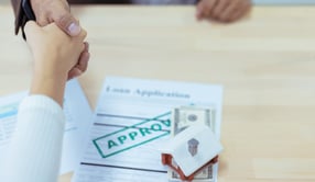 Home approval documents with house and money on paper 