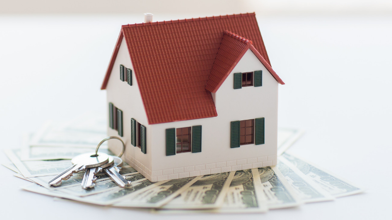 House sitting on money with keys