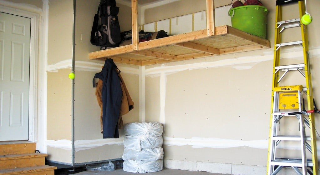 Recently-hung wooden shelves and painted walls in a garage.