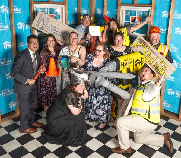 Party guests at the photo booth in costumes with props.