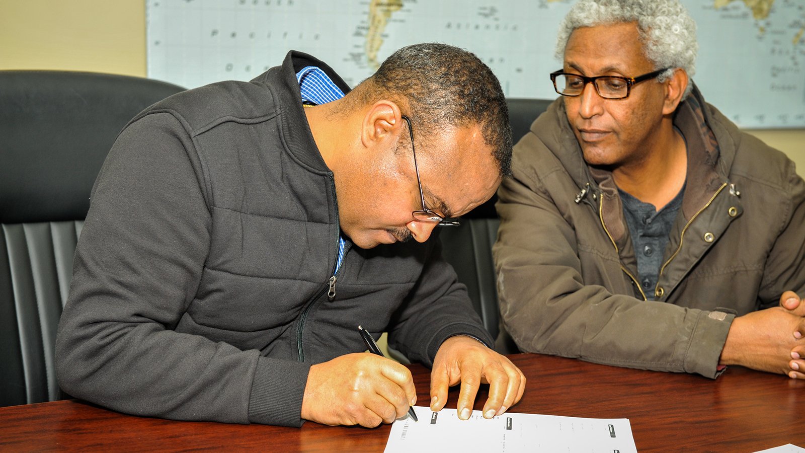 Two people signing mortgage documents.